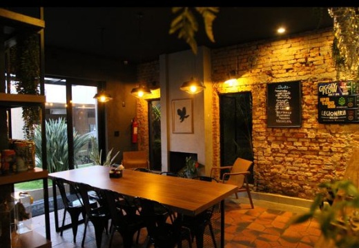 Salão do restaurante Hawks BBQ com parede de tijolos e iluminação aconchegante