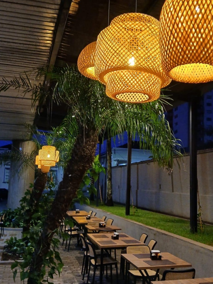 Hawks Craft Beer & BBQ à noite com luminárias e clima acolhedor em Ouro Fino